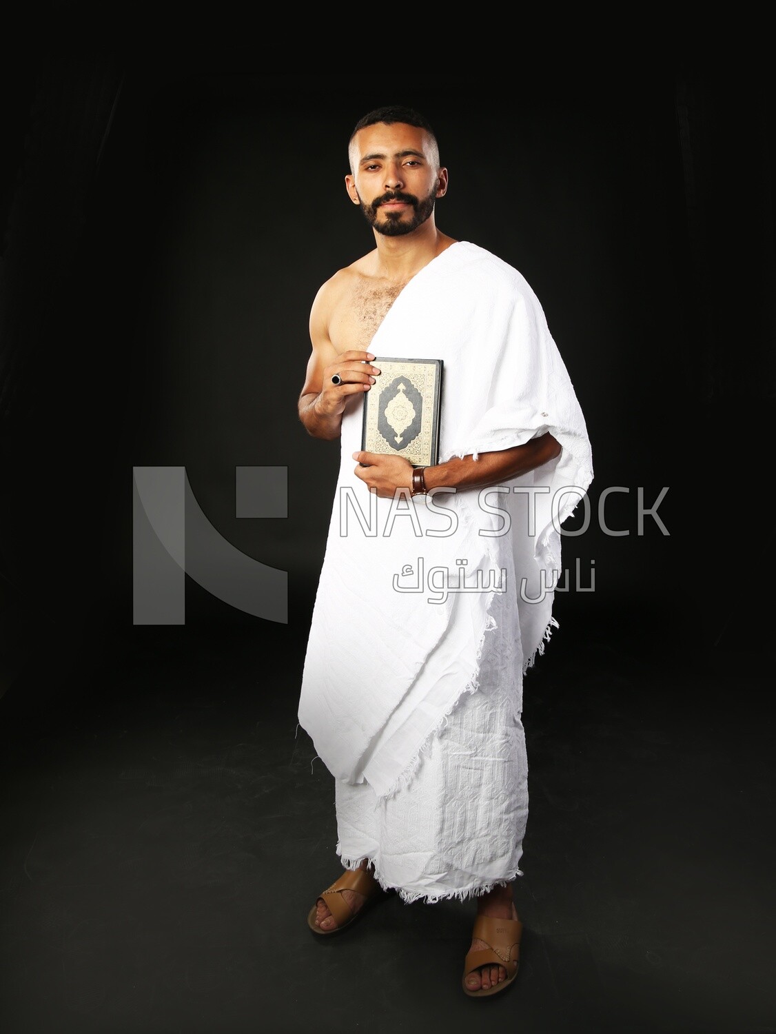 A man wearing an ihram dress prays