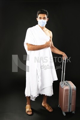 A man wearing an ihram dress with his luggage