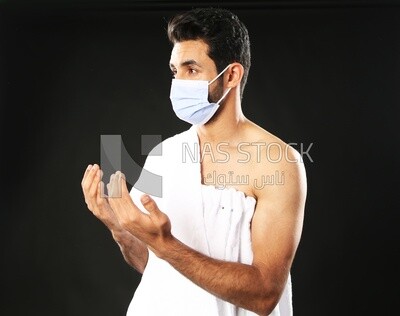 A man wearing an ihram dress with a mask
