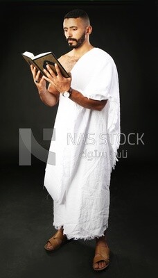 A man wearing an ihram dress prays