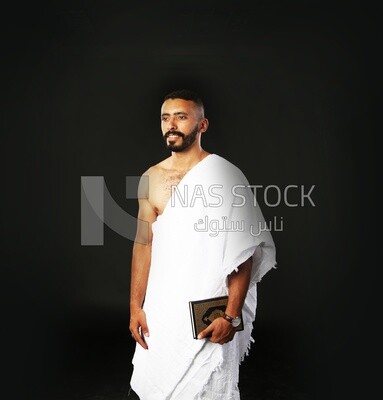 A man wearing an ihram dress prays