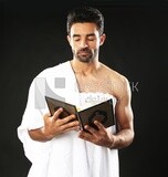 A man wearing an ihram dress prays