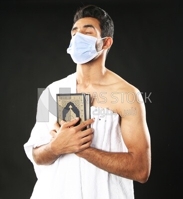 A man wearing an ihram dress prays