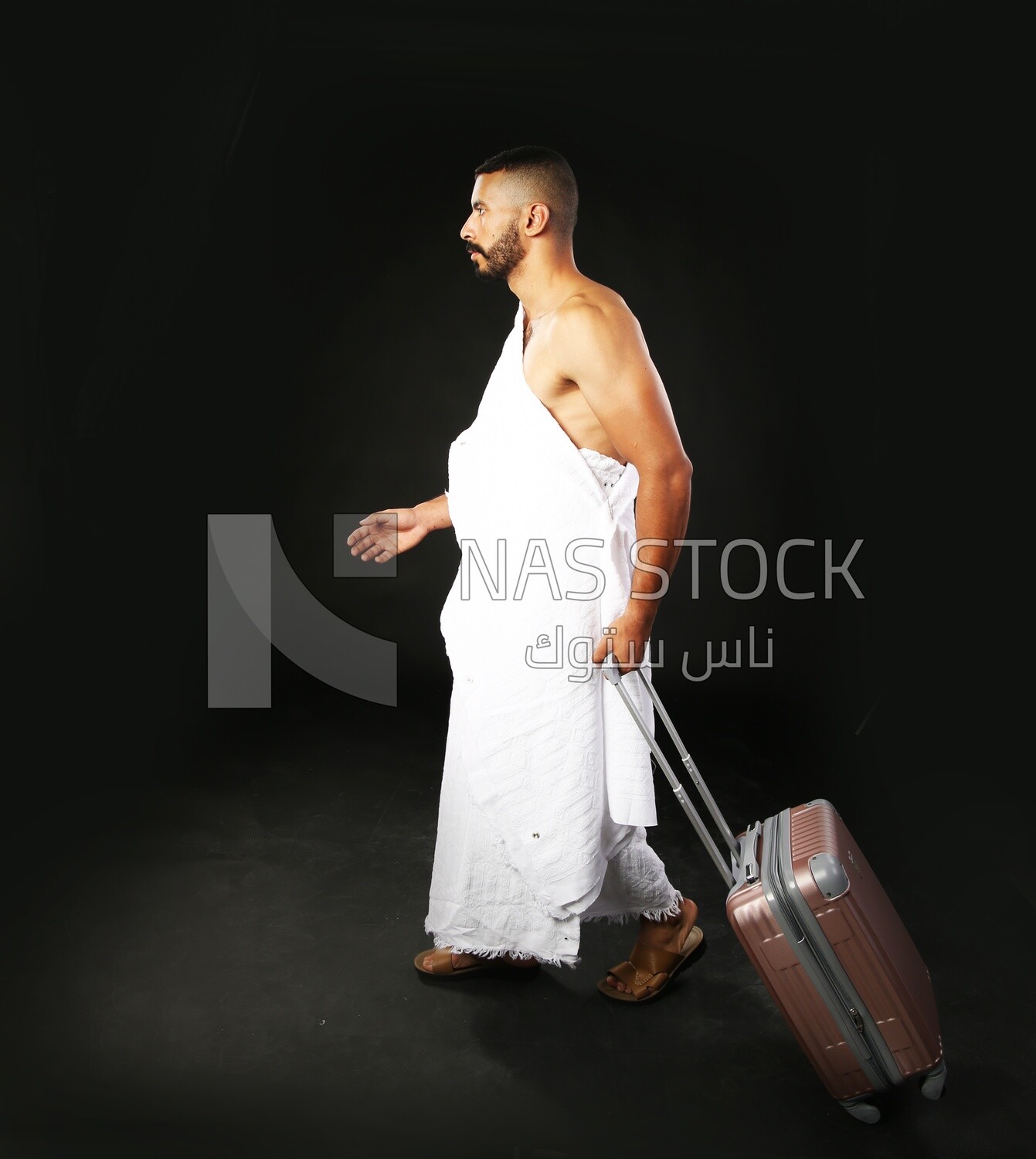 A man wearing an ihram dress with his luggage
