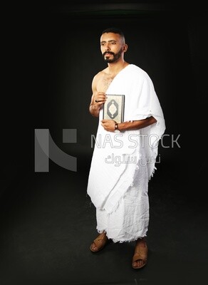 A man wearing an ihram dress prays