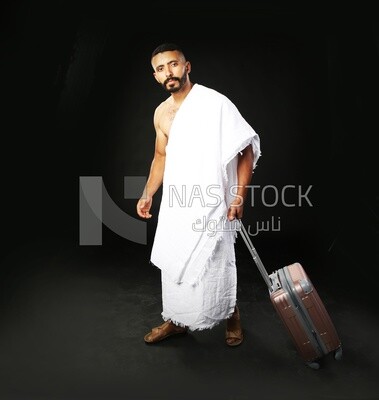 A man wearing an ihram dress with his luggage