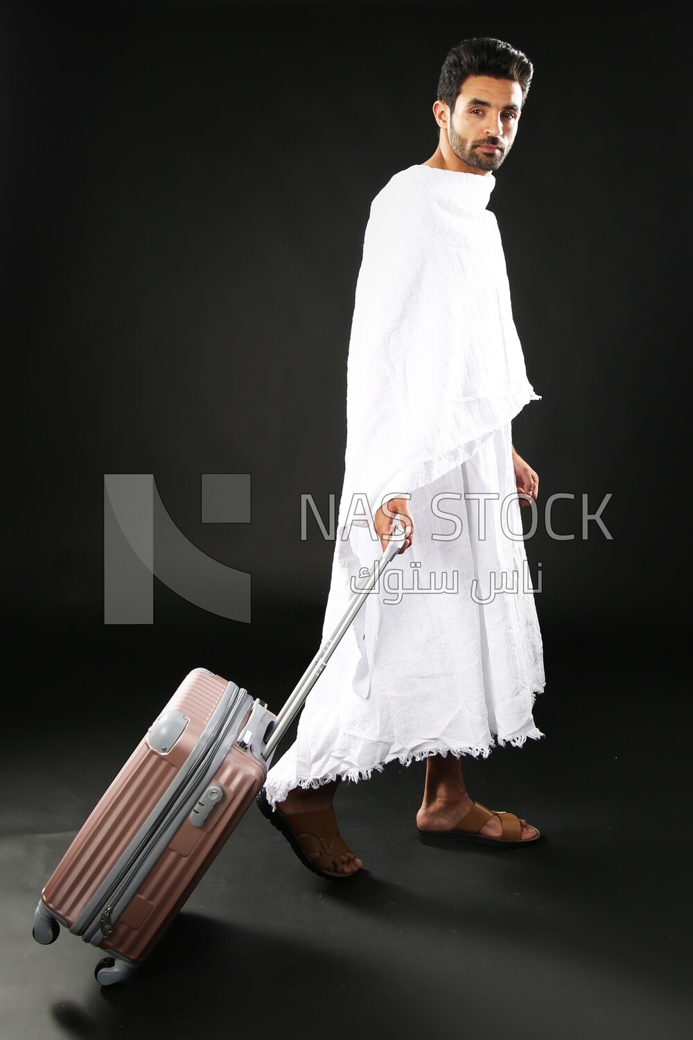 A man wearing an ihram dress with his luggage
