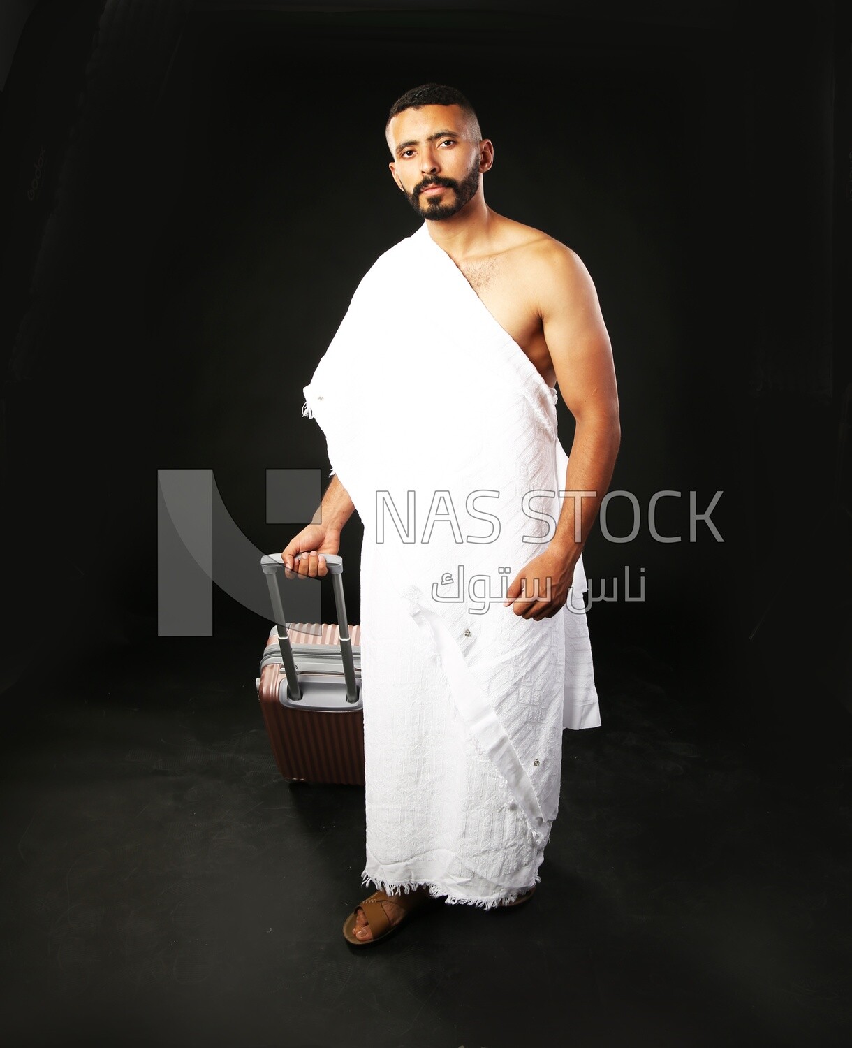 A man wearing an ihram dress with his luggage