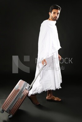 A man wearing an ihram dress with his luggage