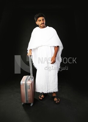 A man wearing an ihram dress with his luggage