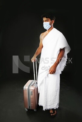 A man wearing an ihram dress with his luggage