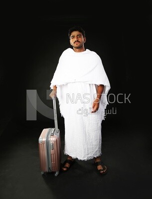 A man wearing an ihram dress with his luggage