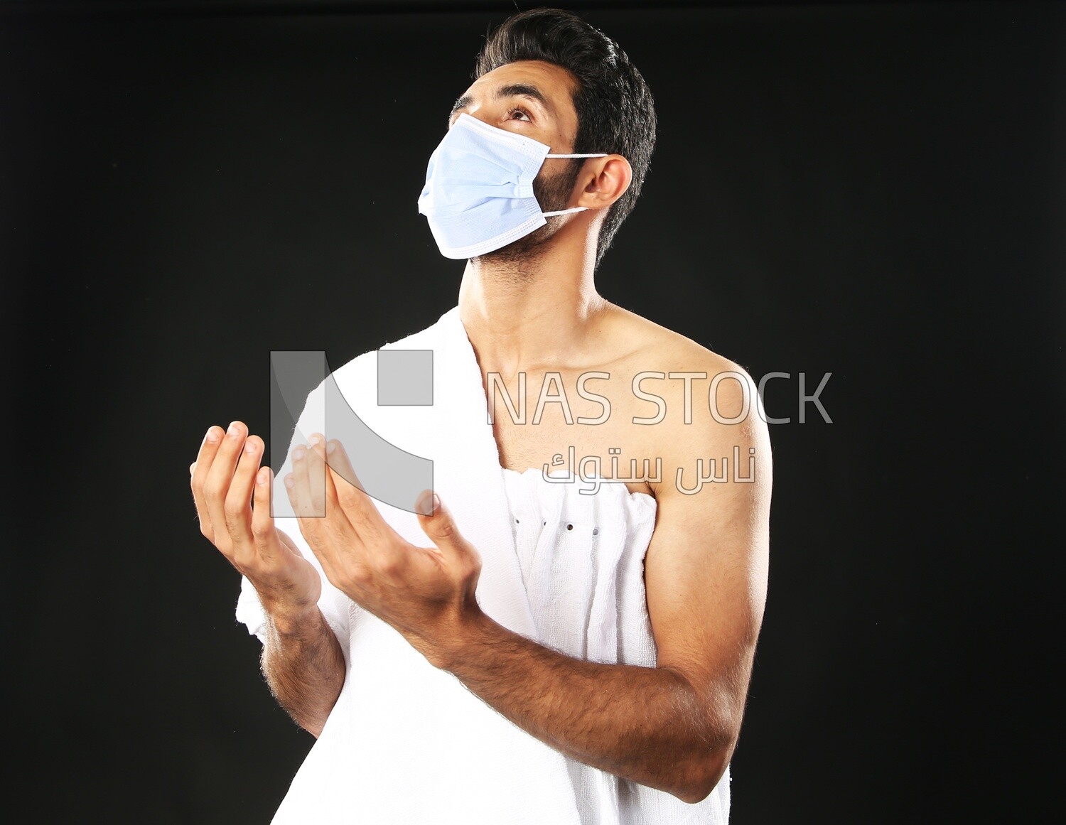 A man wearing an ihram dress with a mask