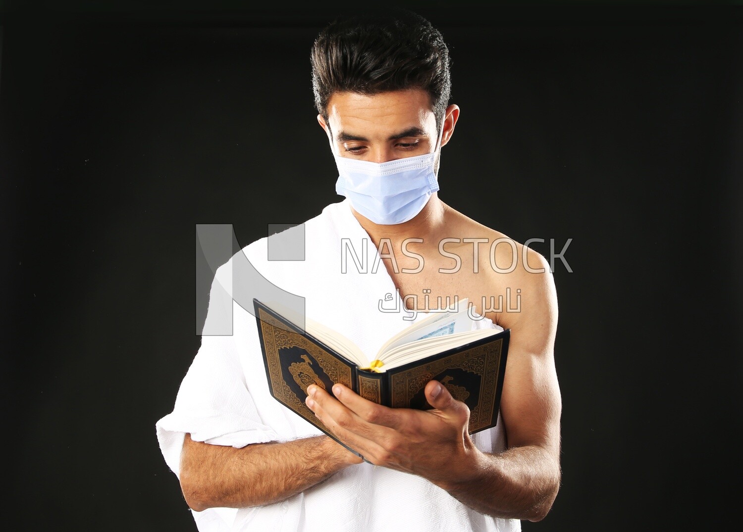 A man wearing an ihram dress prays