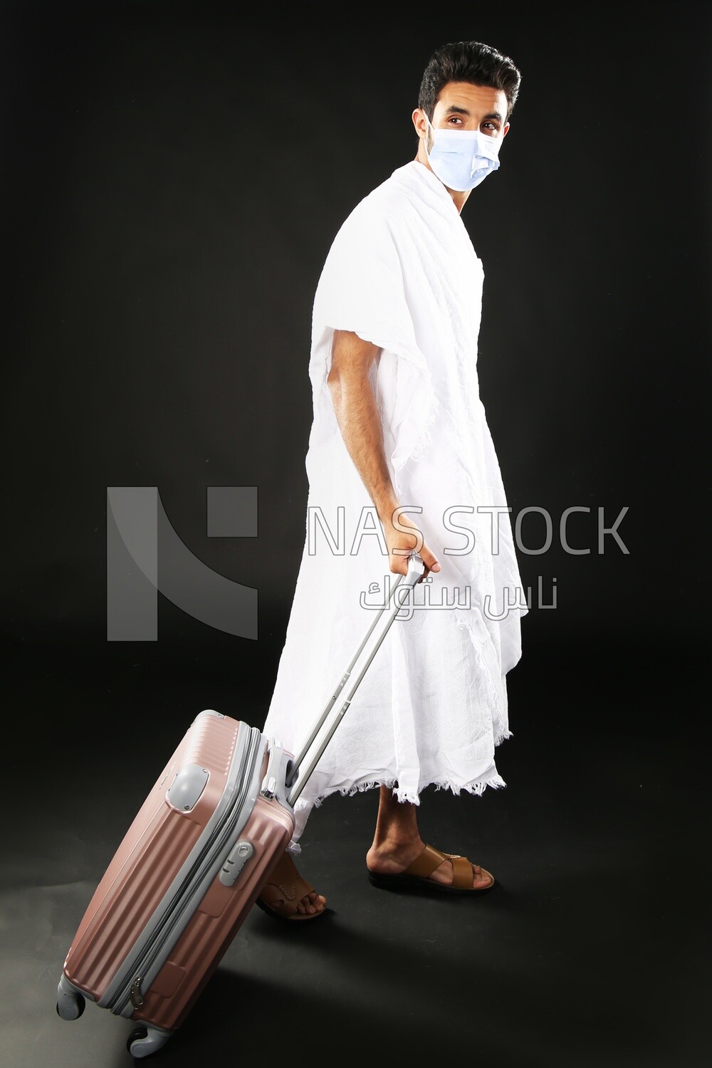 A man wearing an ihram dress with his luggage