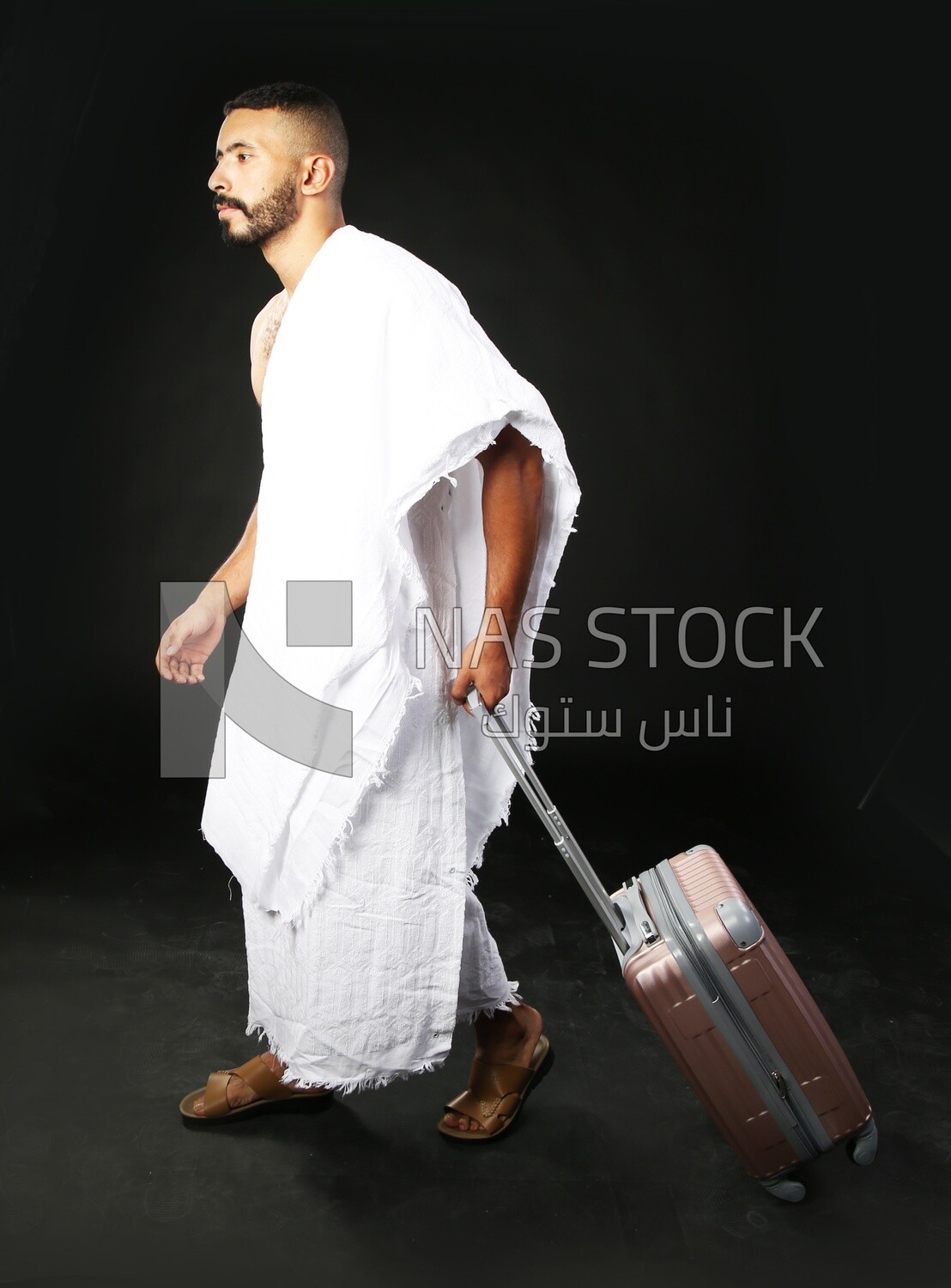 A man wearing an ihram dress with his luggage