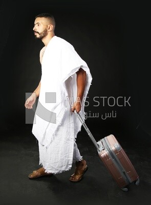 A man wearing an ihram dress with his luggage