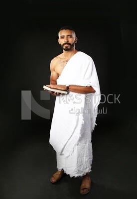 A man wearing an ihram dress prays