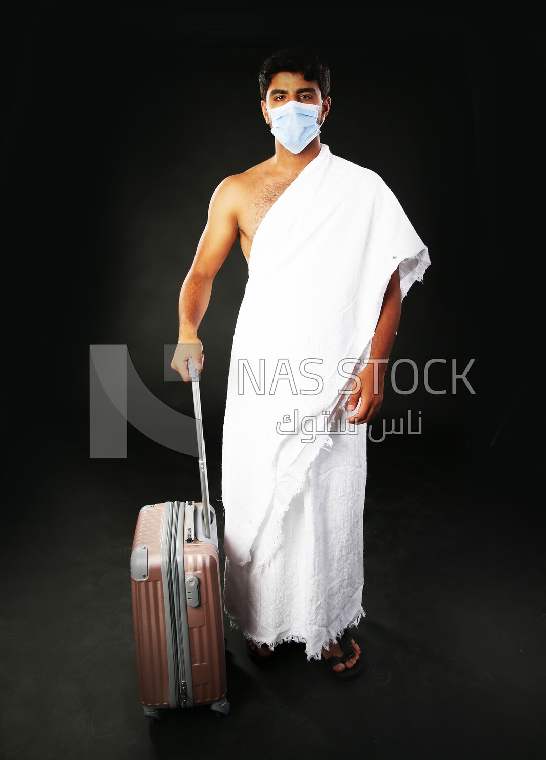A man wearing an ihram dress with his luggage