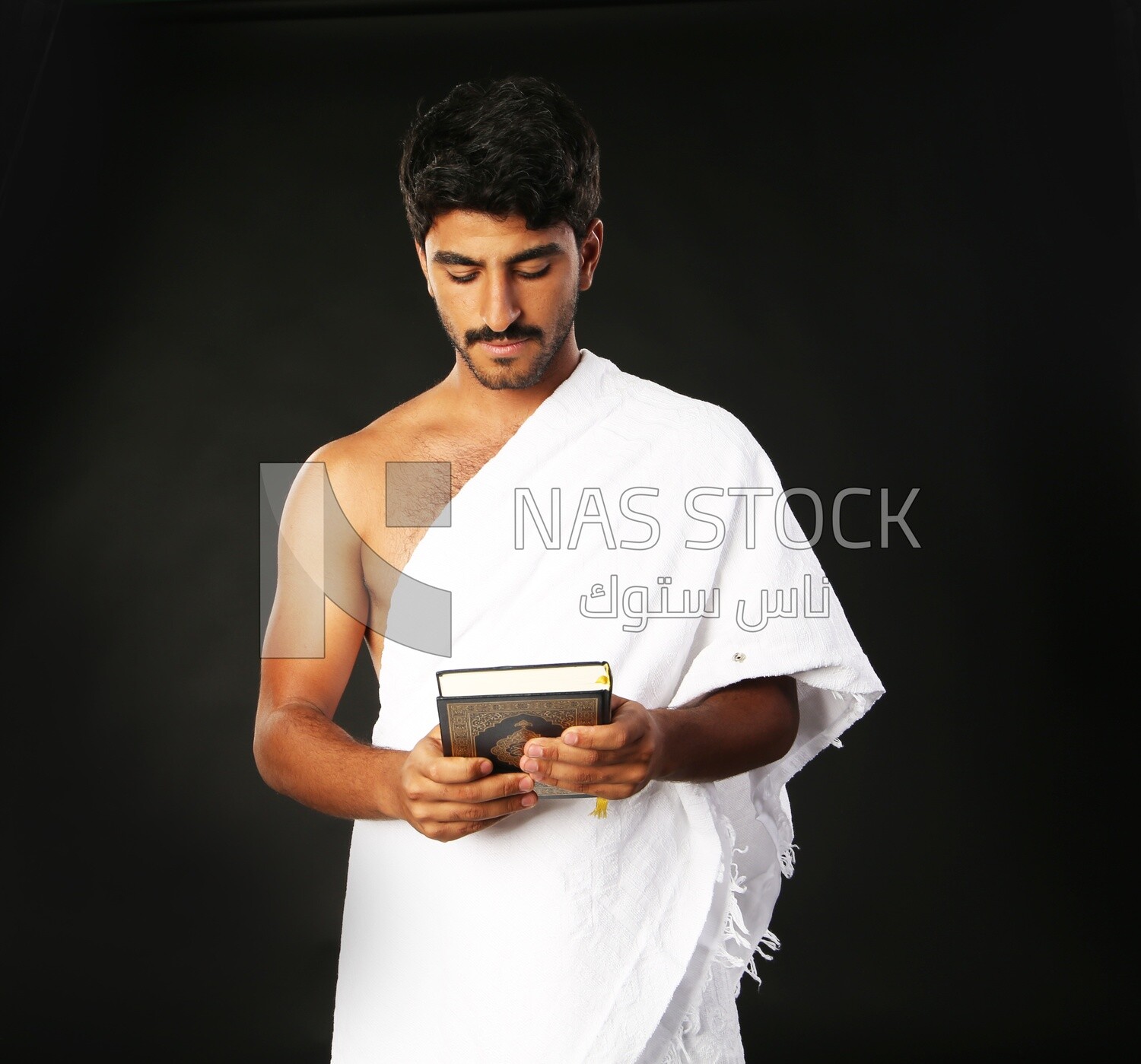 A man wearing an ihram dress prays