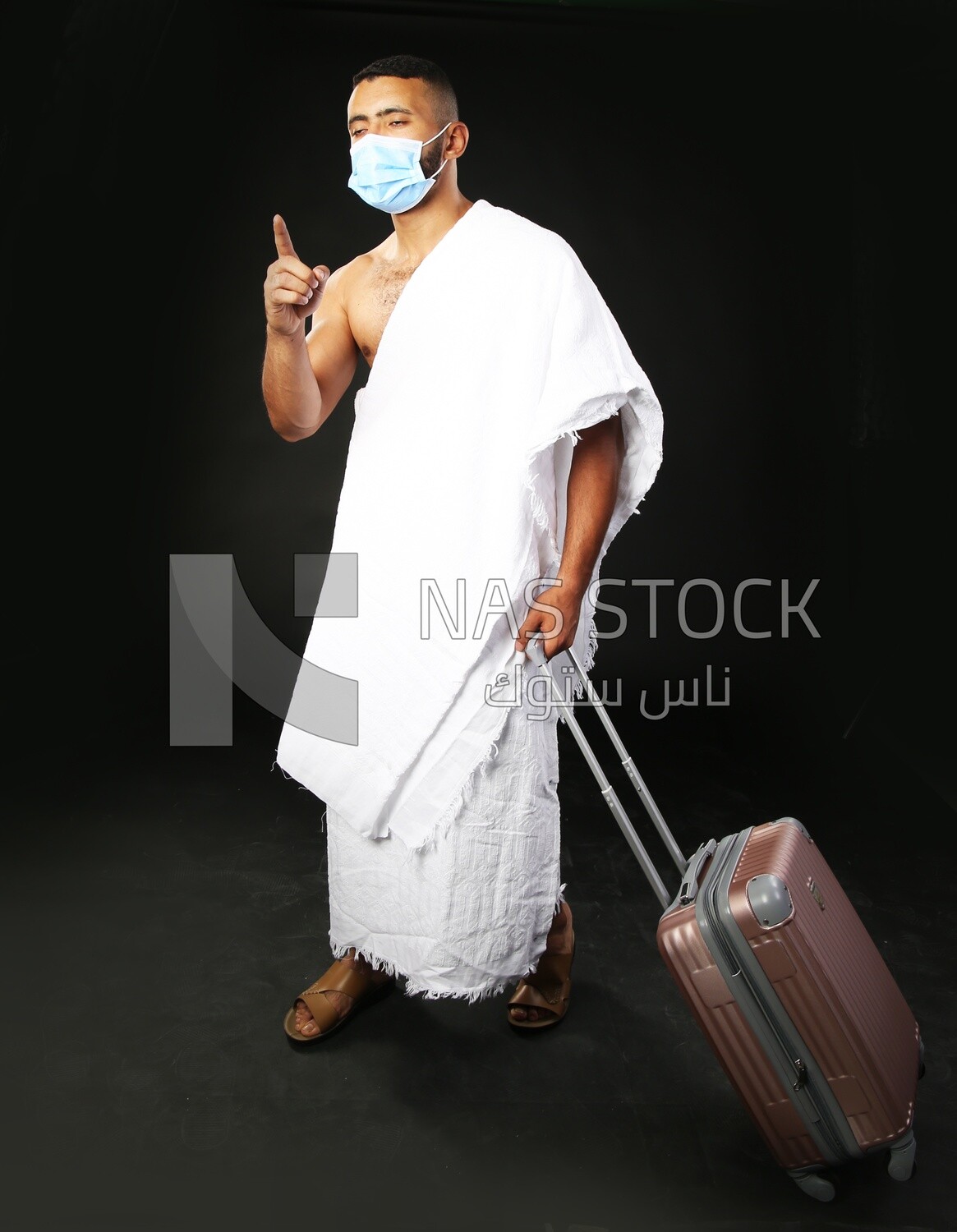 A man wearing an ihram dress with his luggage