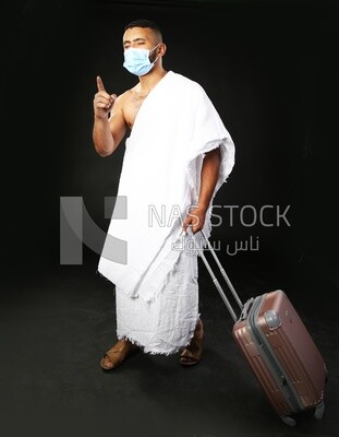A man wearing an ihram dress with his luggage