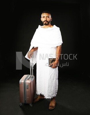 A man wearing an ihram dress prays