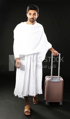 A man wearing an ihram dress with his luggage