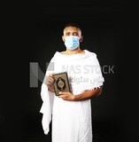 A man wearing an ihram dress prays