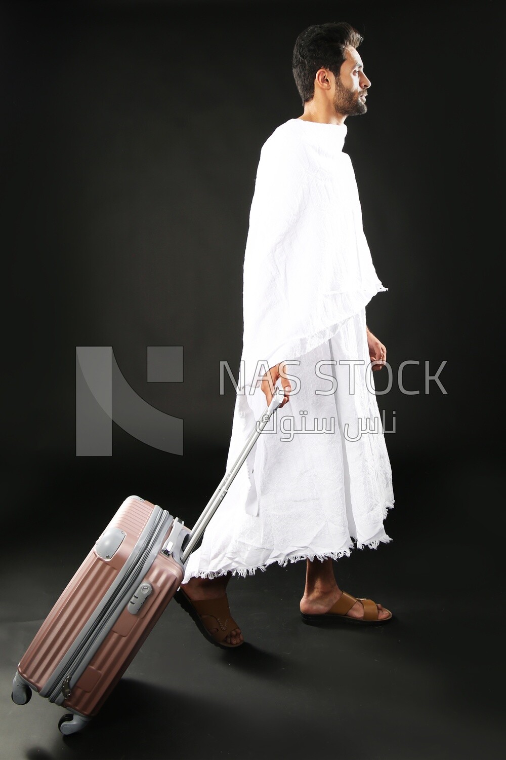 A man wearing an ihram dress with his luggage