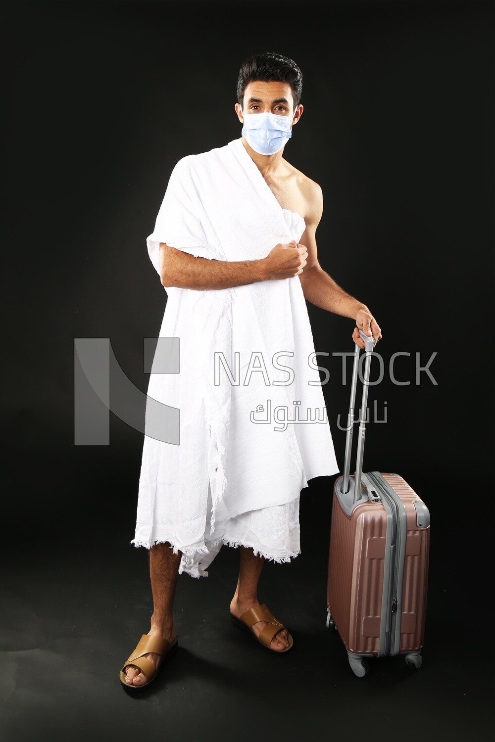 A man wearing an ihram dress with his luggage