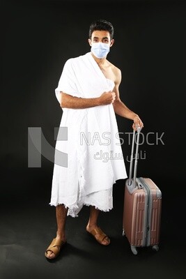 A man wearing an ihram dress with his luggage