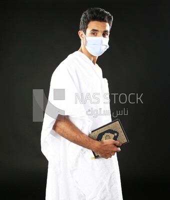 A man wearing an ihram dress prays