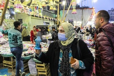 Egyptian woman buys a small lantern from a store