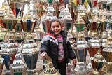 little girl stands in the middle of the lanterns happily celebrating Ramadan