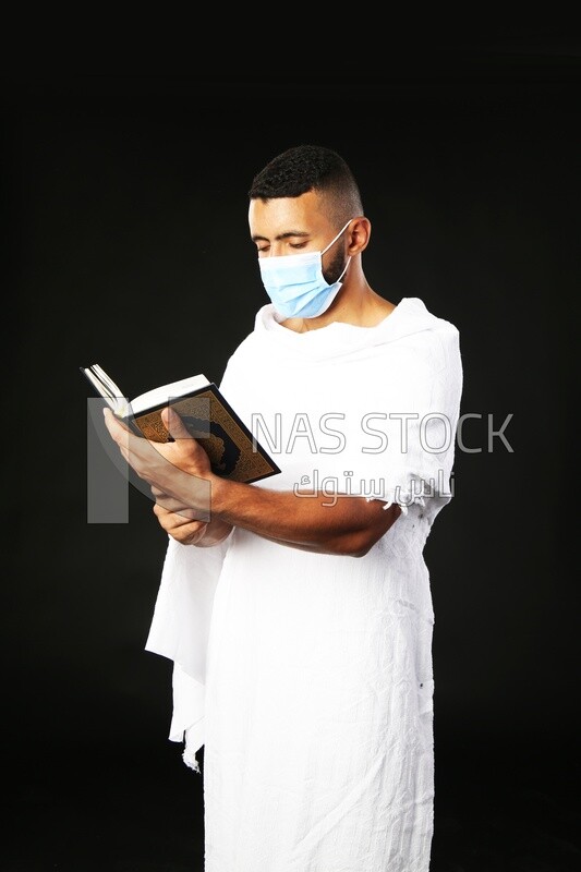 A man wearing an ihram dress prays