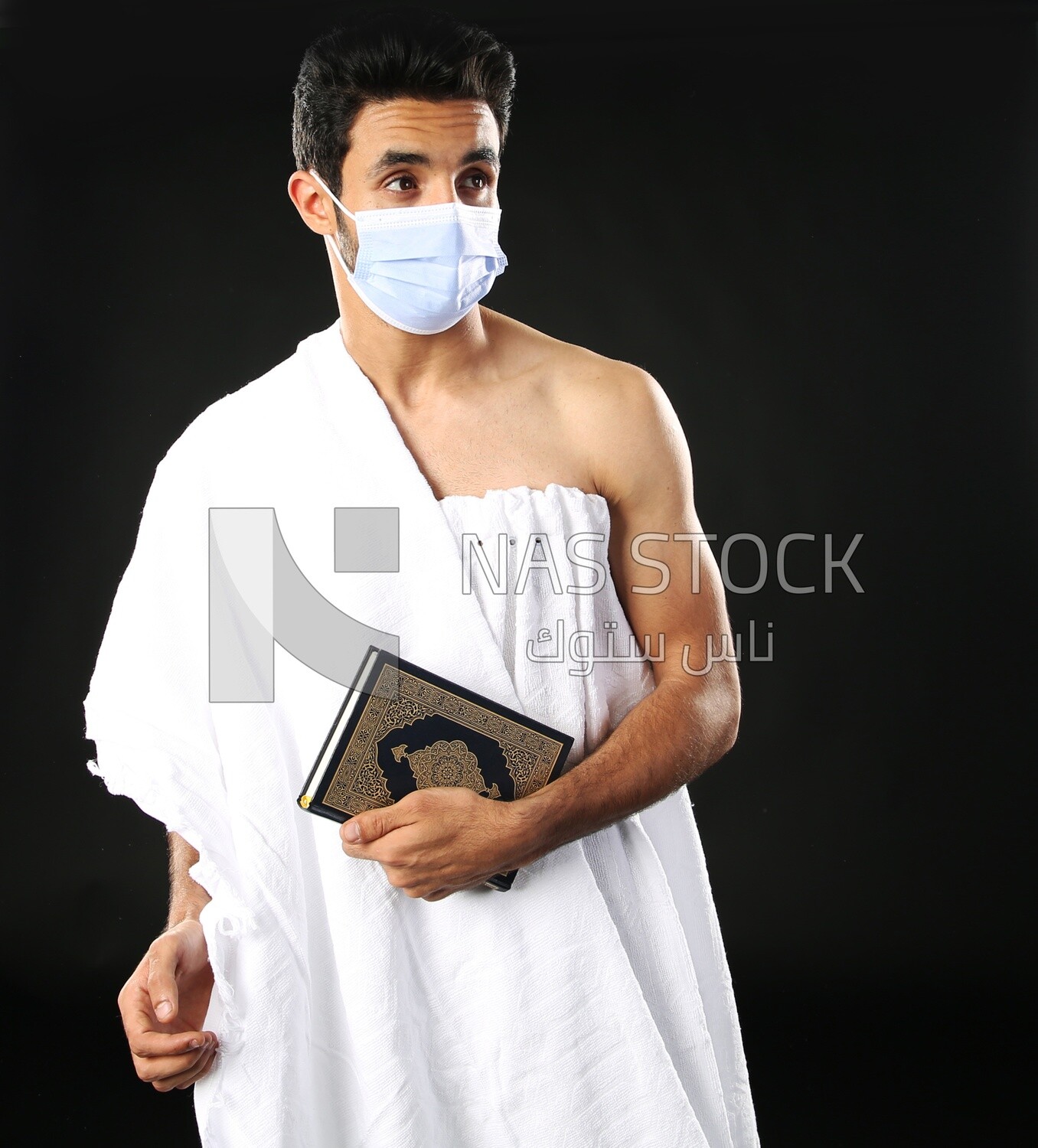 A man wearing an ihram dress prays