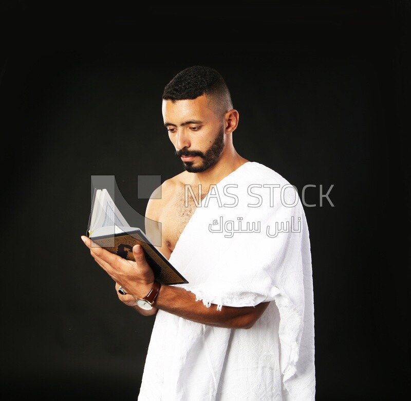 A man wearing an ihram dress prays