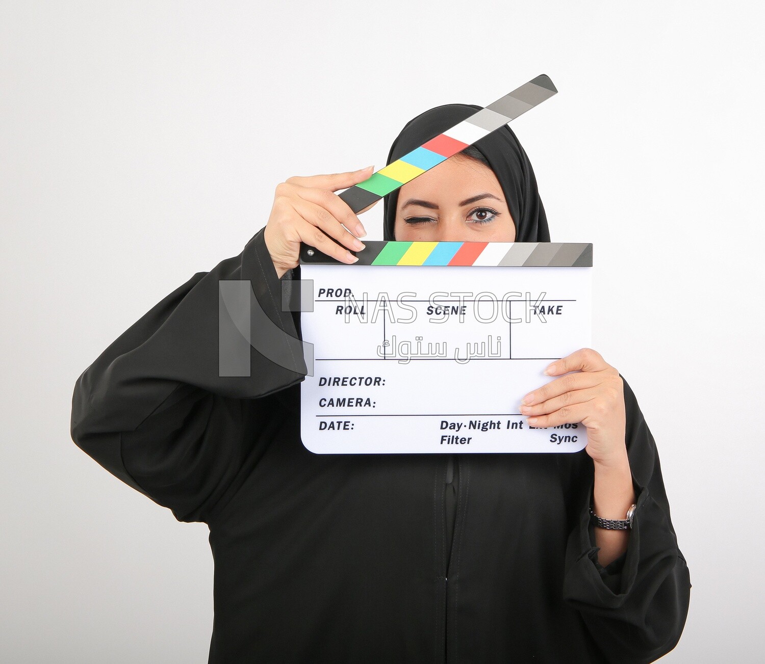A woman with a hijab holding a clapperboard