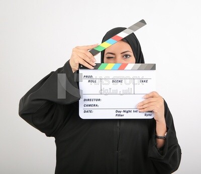 A woman with a hijab holding a clapperboard