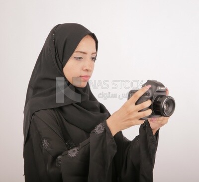 A woman with a hijab holding a camera