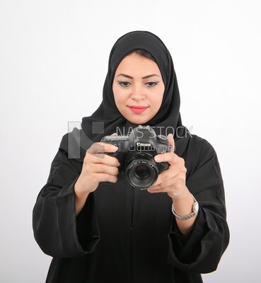 A woman with a hijab holding a camera