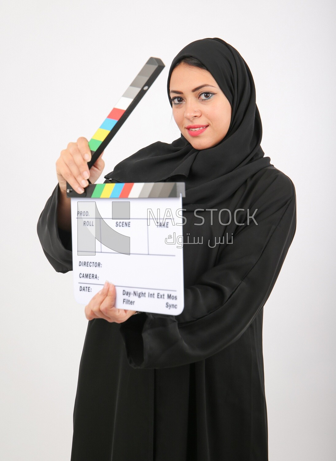 A woman with a hijab holding a clapperboard