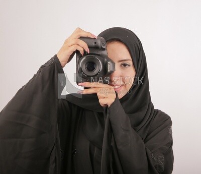 A woman with a hijab holding a camera