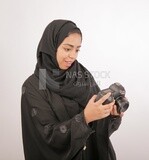 A woman with a hijab holding a camera