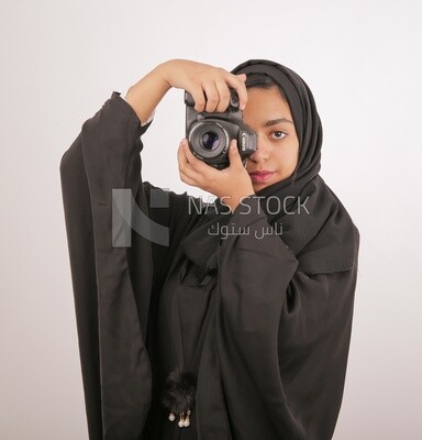 A woman with a hijab holding a camera