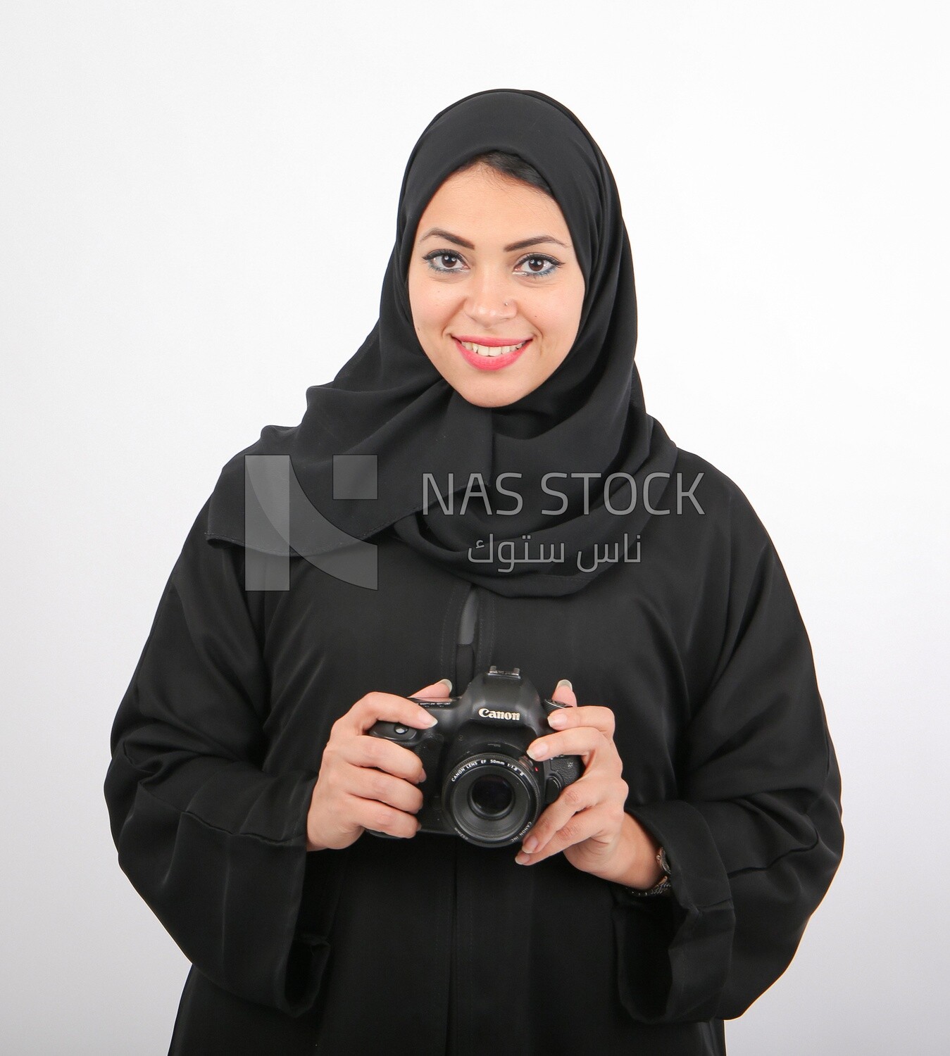 A woman with a hijab holding a camera