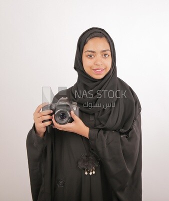 A woman with a hijab holding a camera