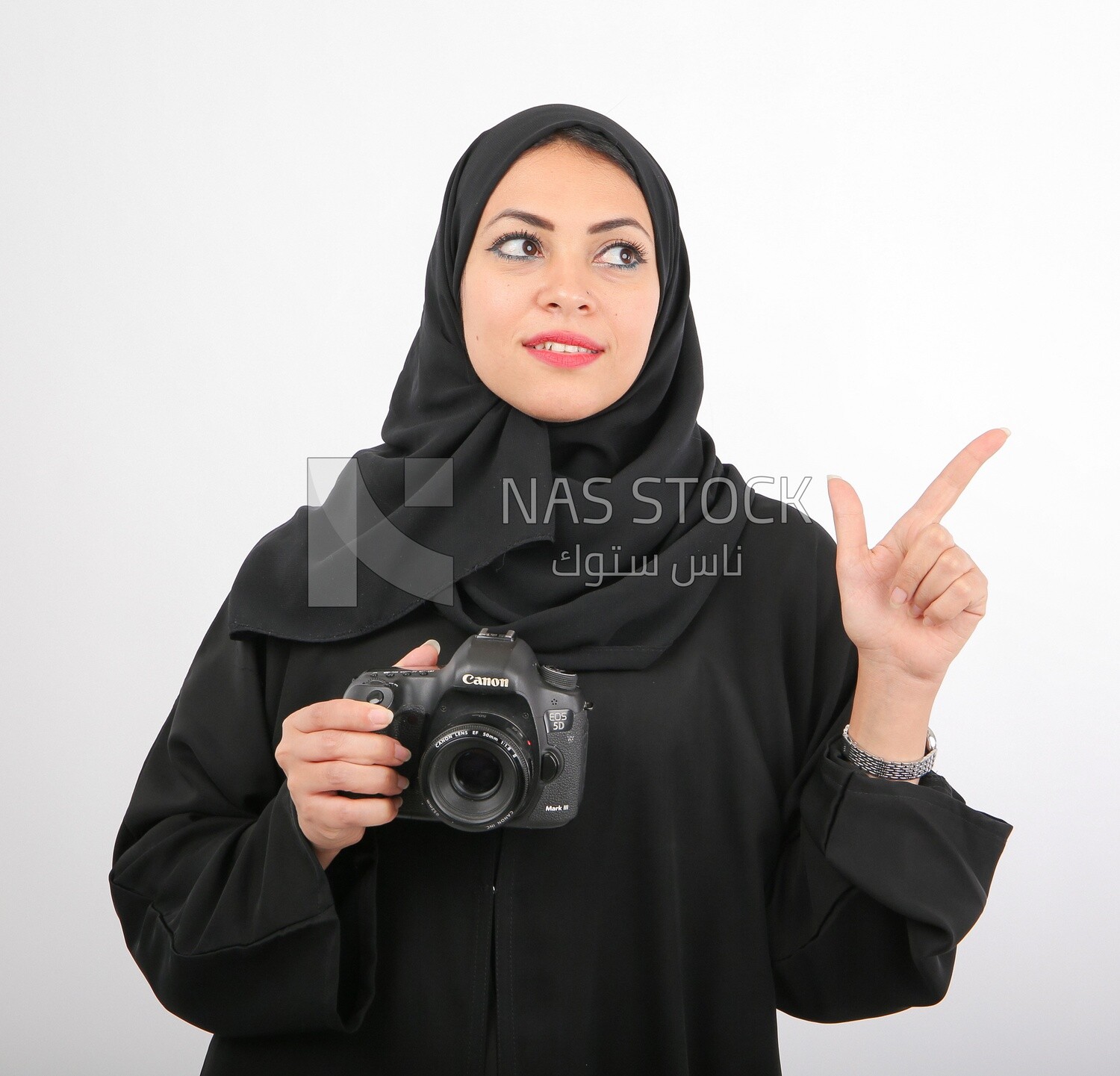 A woman with a hijab holding a camera