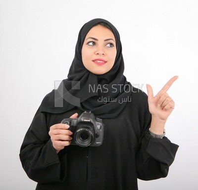 A woman with a hijab holding a camera